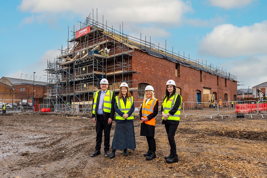 4 people at new construction site launching Gentoo Skills Academy 