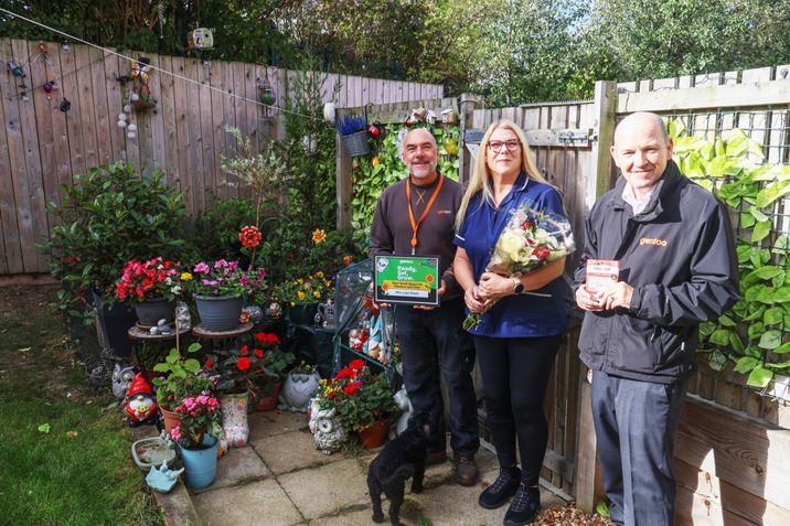 Winner of the Best Small Space, Planters and Pots award standing in their prize-winning garden with two Gentoo colleagues during the award presentation.