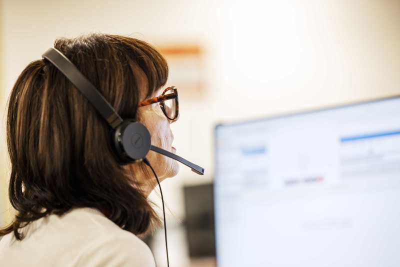 Colleague at computer answering the phone 