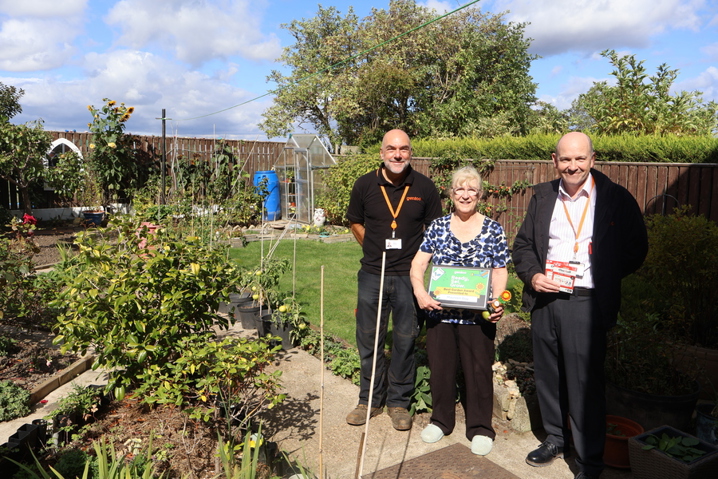 Best Customer Garden award winner standing in their prize-winning garden with two Gentoo colleagues during the award presentation.